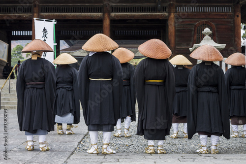 Buddhist monks looking at the Sanmon Gate in Zenko-ji, a buddhist temple located in Nagano, Japan