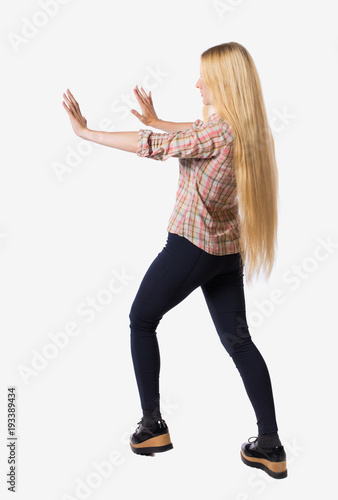back view of woman pushes wall