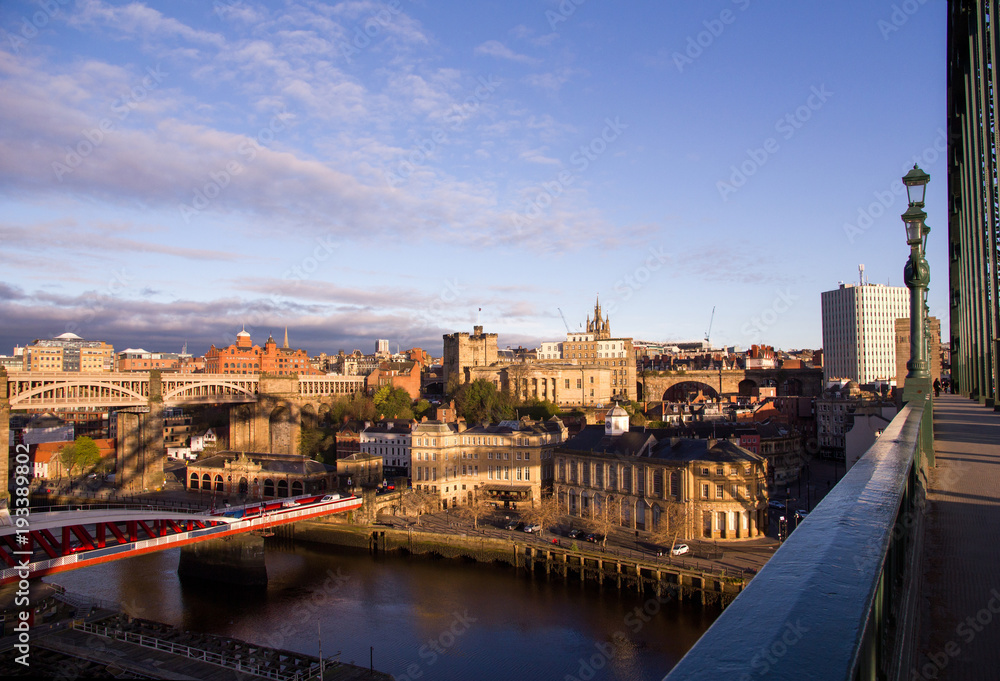 Newcastle Upon Tyne Quayside and Grainger Town areas coloured golden at sunrise, with Tyne Bridge shadow cast across the buildings