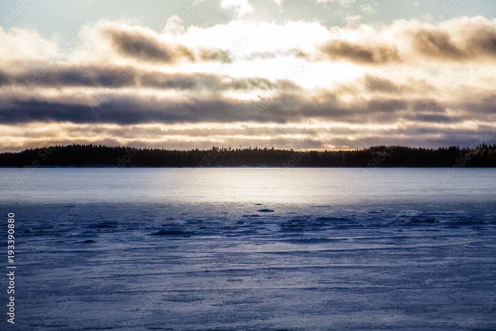 View of the winter lake under the snow and sunset View of the winter lake under the snow and sunset