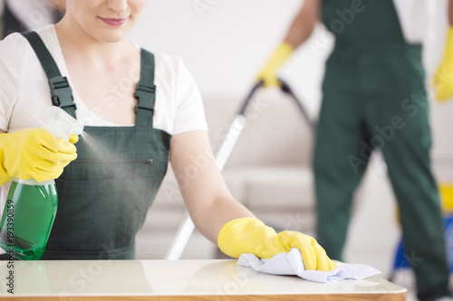 Cleaning lady spraying table