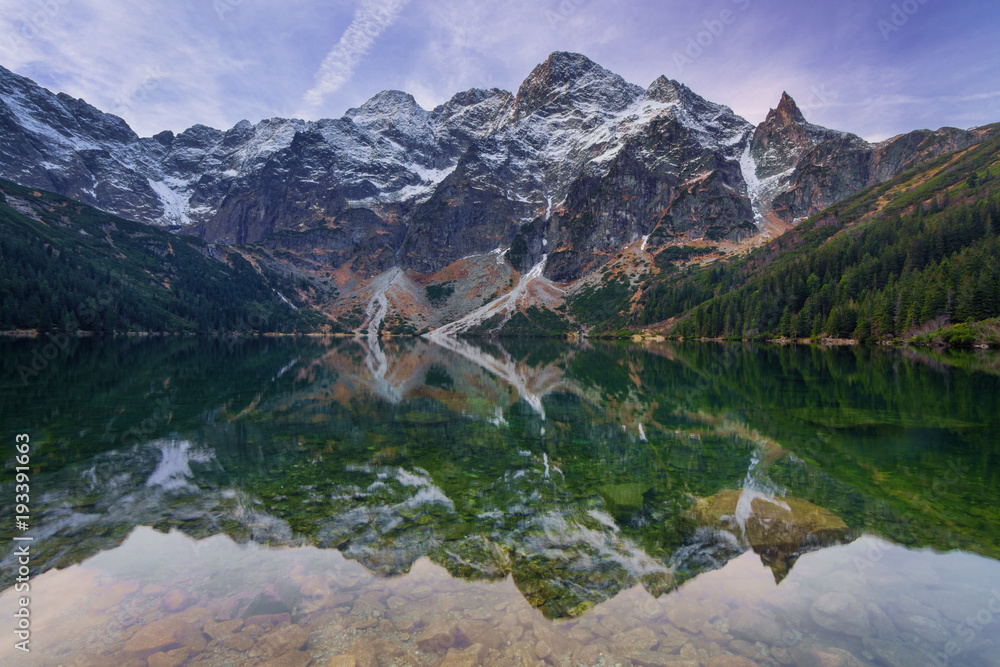 Rocky mountains reflection in the calm lake water.