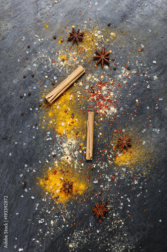 Artistic colorful background of a variety of spices on slate