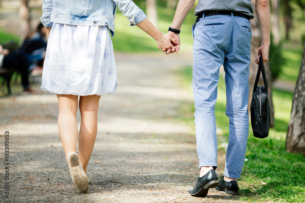 Couple of people holding hands in park