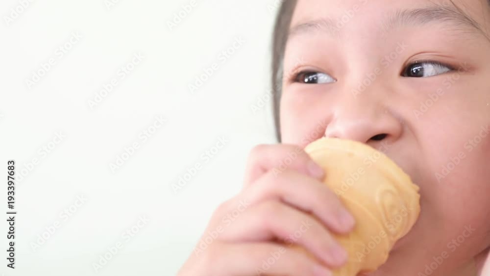 Child eating ice-cream cone at cafe. 
