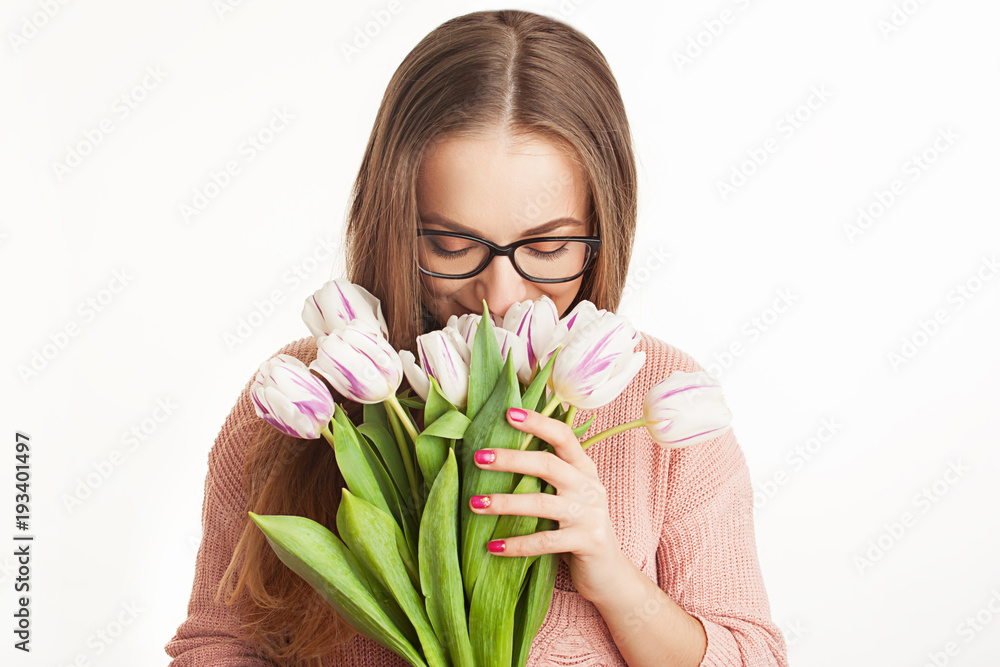 Young, beautiful girl is holding spring flowers in the studio. tulips. portrait on white background