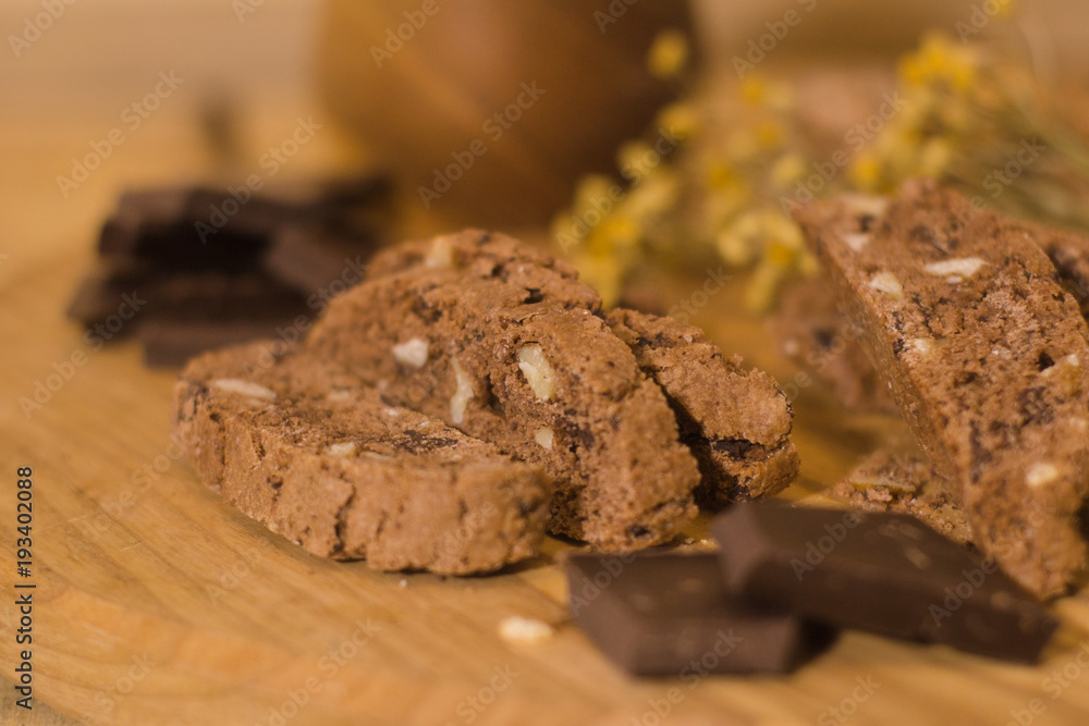 Fototapeta premium bread with candied fruit, chocolate and nuts close up picture, wooden table background