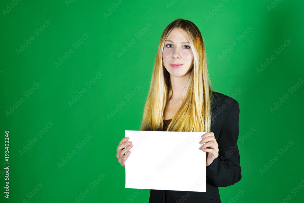 Attractive blonde business woman holding white banner with copy space for additional text or graphic. Girl is posing on a green background Attractive blonde business woman holding white banner with copy space for additional text or graphic. Girl is posing on a green background