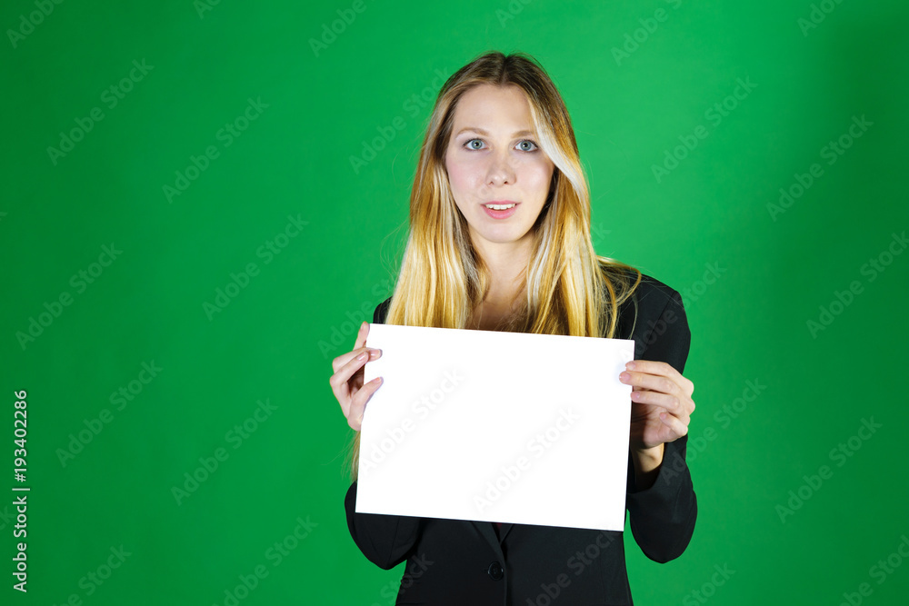 Attractive blonde business woman holding white banner with copy space for additional text or graphic. Girl is posing on a green background Attractive blonde business woman holding white banner with copy space for additional text or graphic. Girl is posing on a green background