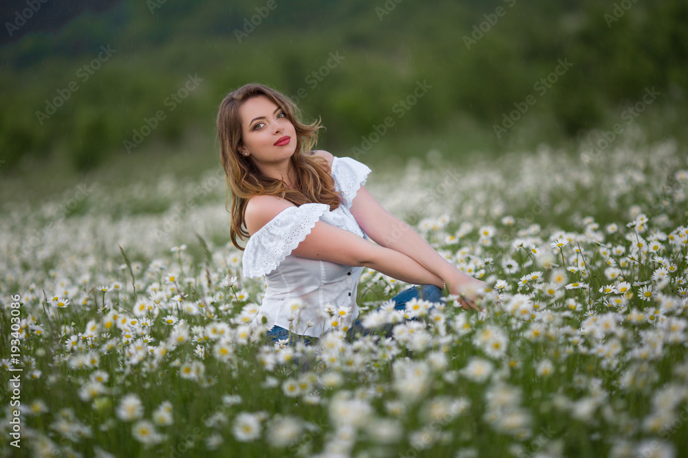 Beautiful happy woman on the camomile field is wearing white dress, spring time Beautiful happy woman on the camomile field is wearing white dress, spring time