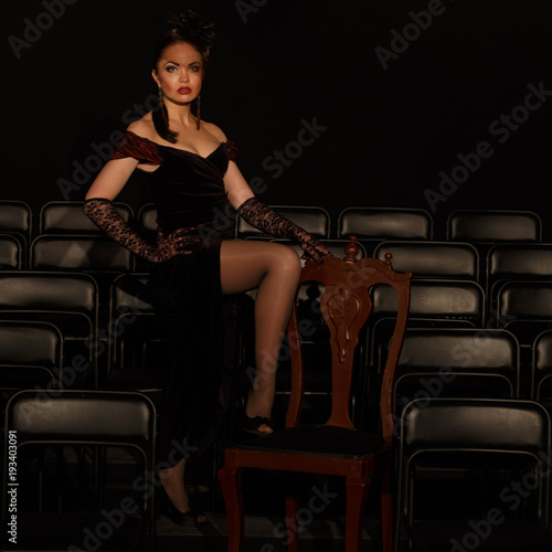 Woman in retro style stand near chairs