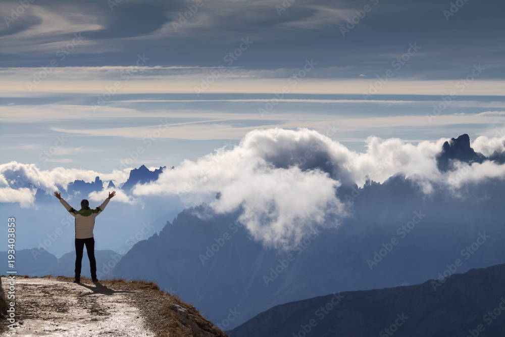 Anonymer Wanderer mit erhobenen Armen vor einer Bergkulisse. Bergpanorama in den Dolomiten.
