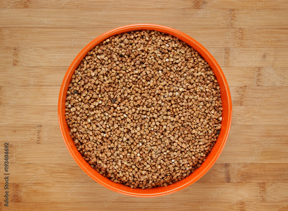 buckwheat groats in a bowl on a wooden table buckwheat groats in a bowl on a wooden table