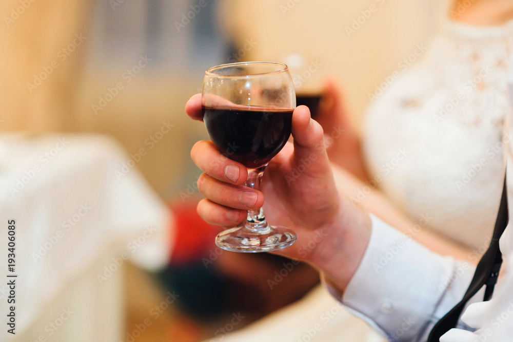 glass of red wine in the hand of a man close-up with a blurred background glass of red wine in the hand of a man close-up with a blurred background