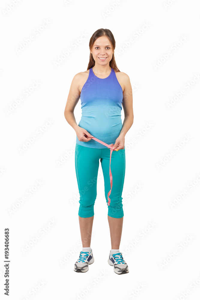 Sporty pregnant woman with a tape measure, isolated Sporty pregnant woman with a tape measure, isolated