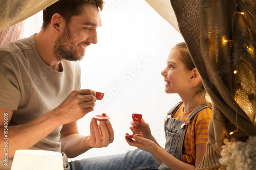 Photography family playing tea party in kids tent at home