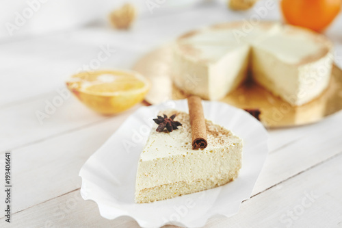 light diet Cheesecake with oranges and cinnamon on the white wooden background