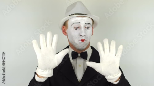 A sad mime shows tricks