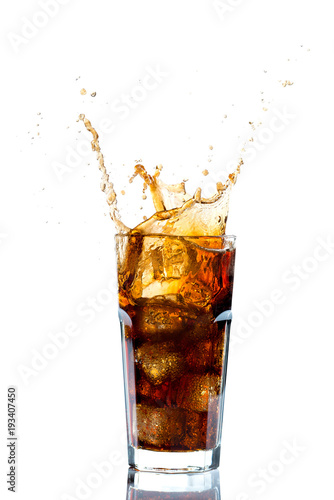 Ice splashing on a glass of a Cola drink against a white background