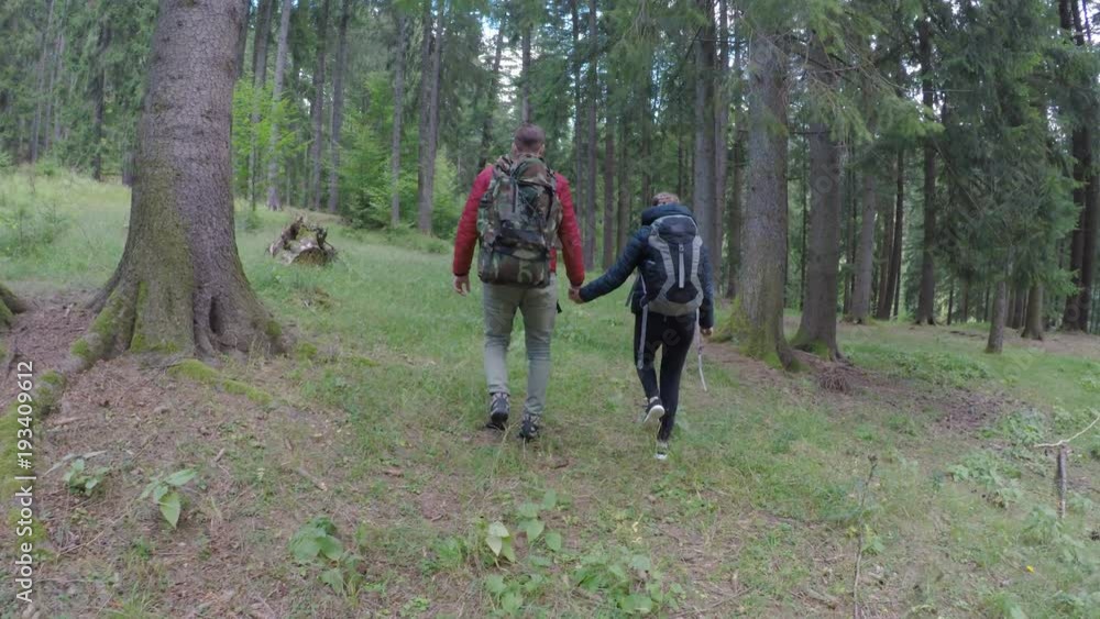 Romantic young man and woman lovers walking together exploring forest trip recreational activity in weekend concept Romantic young man and woman lovers walking together exploring forest trip recreational activity in weekend concept