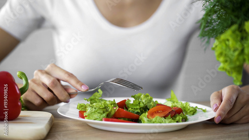 Woman sitting at the table with salad plate, healthy nutrition, energy support