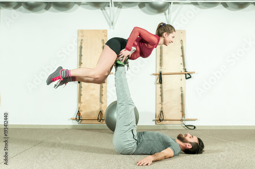 Young beautiful fitness couple workout extreme acrobatic exercise as preparation for the competition, selective focus