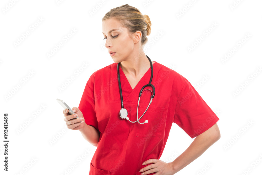 Attractive female doctor browsing on smartphone. Attractive female doctor browsing on smartphone.