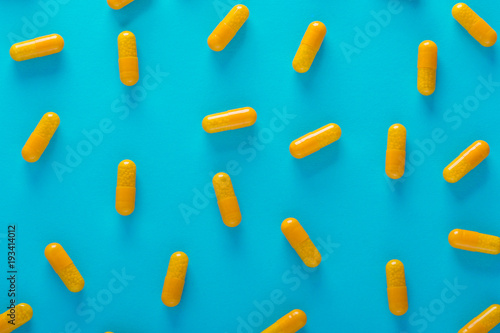 yellow pills on blue background top view