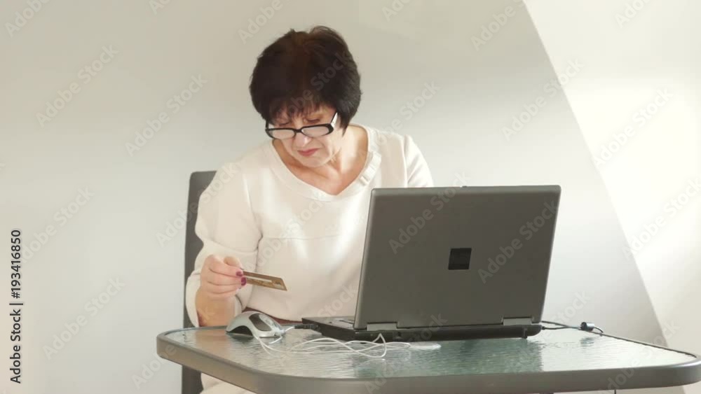 Pensioner makes purchases in the online store using the Internet and bank cards Pensioner makes purchases in the online store using the Internet and bank cards