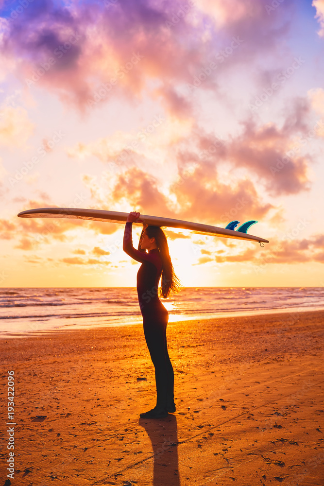 Silhouette with surfer girl holding surfboard on a beach at warm sunset or sunrise. Surfer and ocean Silhouette with surfer girl holding surfboard on a beach at warm sunset or sunrise. Surfer and ocean