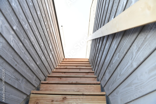 Holztreppenstufen zwischen zwei Holzwänden mit Handlauf