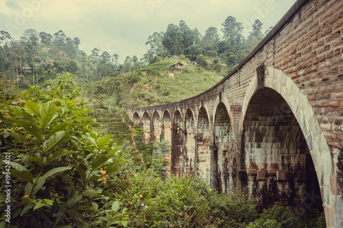 Structure of the historical Nine Arches Bridge in beautiful tropical landscape with of green forest and village. Rural Sri Lanka