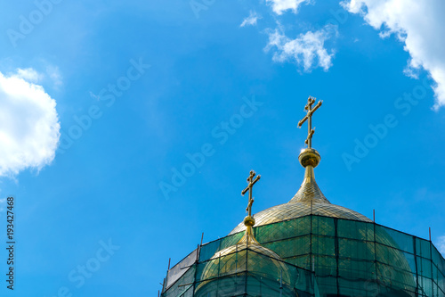 Gold-plated dome with a cross in the scaffolding