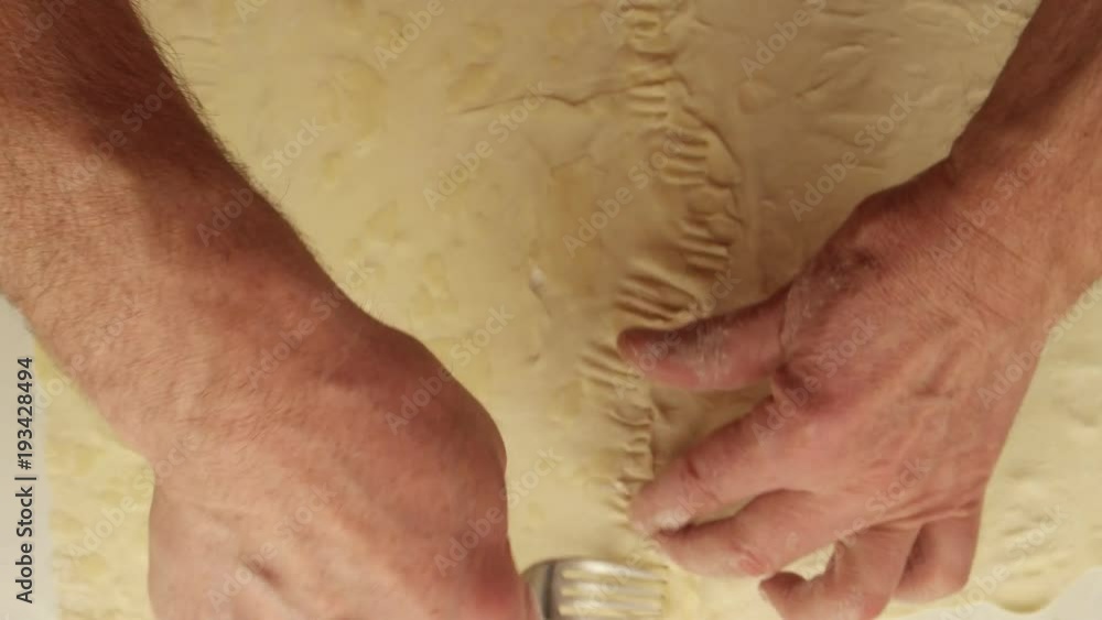 Man spreads the various sauces evenly in the prepared dough Man spreads the various sauces evenly in the prepared dough