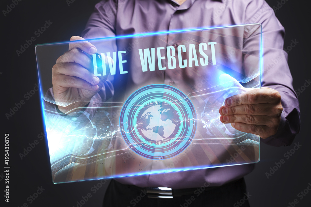 The concept of business, technology, the Internet and the network. A young entrepreneur working on a virtual screen of the future and sees the inscription: Live webcast The concept of business, technology, the Internet and the network. A young entrepreneur working on a virtual screen of the future and sees the inscription: Live webcast