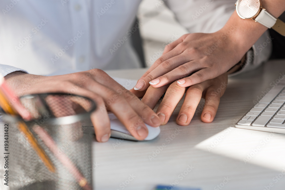 cropped shot of manageress holding hand of colleague at work cropped shot of manageress holding hand of colleague at work