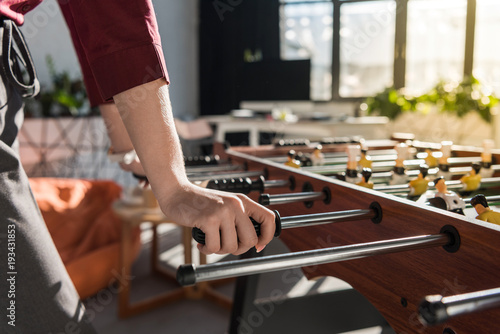 cropped shot of businesswoman playing table football at office