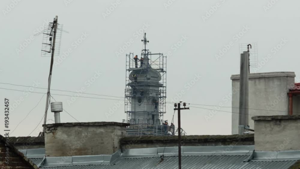 Time lapses workers walk at the construction reconstruction site of a church tower Time lapses workers walk at the construction reconstruction site of a church tower