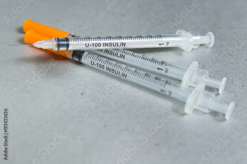 Insulin syringe on gray background.
