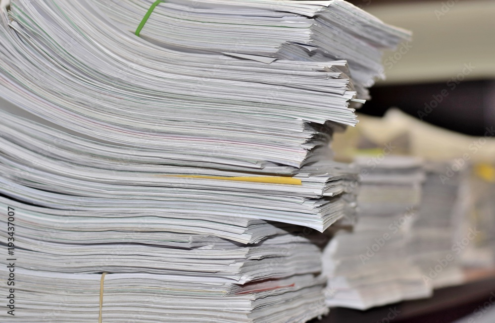 Stacks of paperwork sitting on an office desk in a messy but organized fashion. Suggests a stressful environment where deadlines must be met. Stacks of paperwork sitting on an office desk in a messy but organized fashion. Suggests a stressful environment where deadlines must be met.