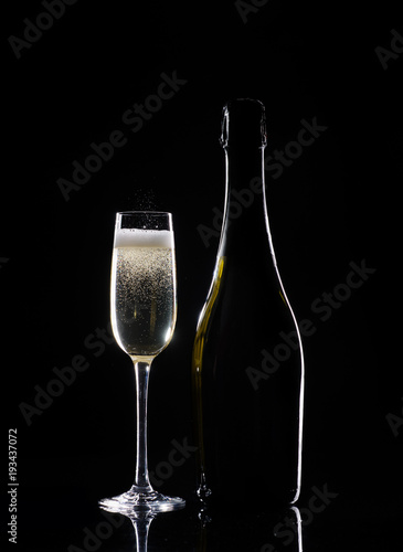 Silhouette champagne. Champagne pouring into glass on black background