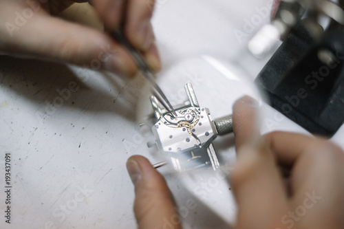 Close up of watchmaker repair clockwork under magnifier