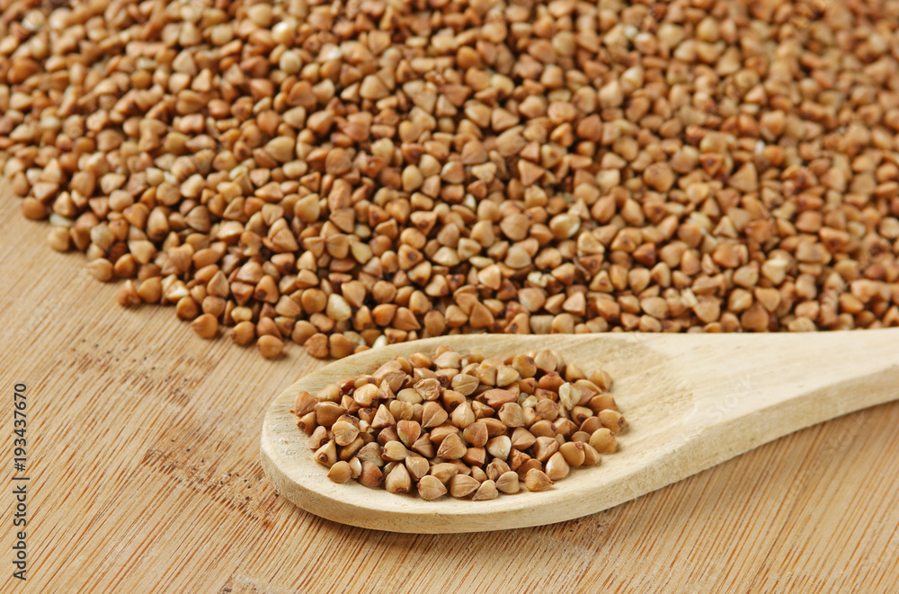 buckwheat groats and wooden spoon on the kitchen table