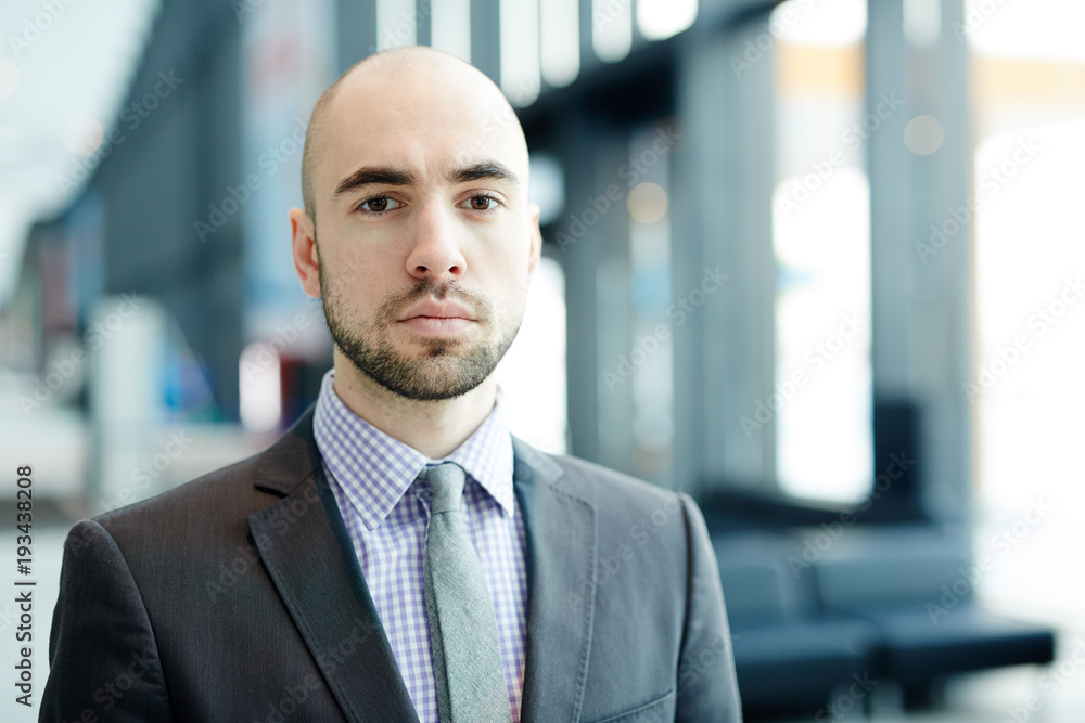 Young business traveler in suit and tie looking at camera in airport Young business traveler in suit and tie looking at camera in airport