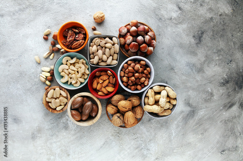 mixed nuts on grey background. Healthy food and snack. Walnut, pecan, almonds, hazelnuts and cashews.