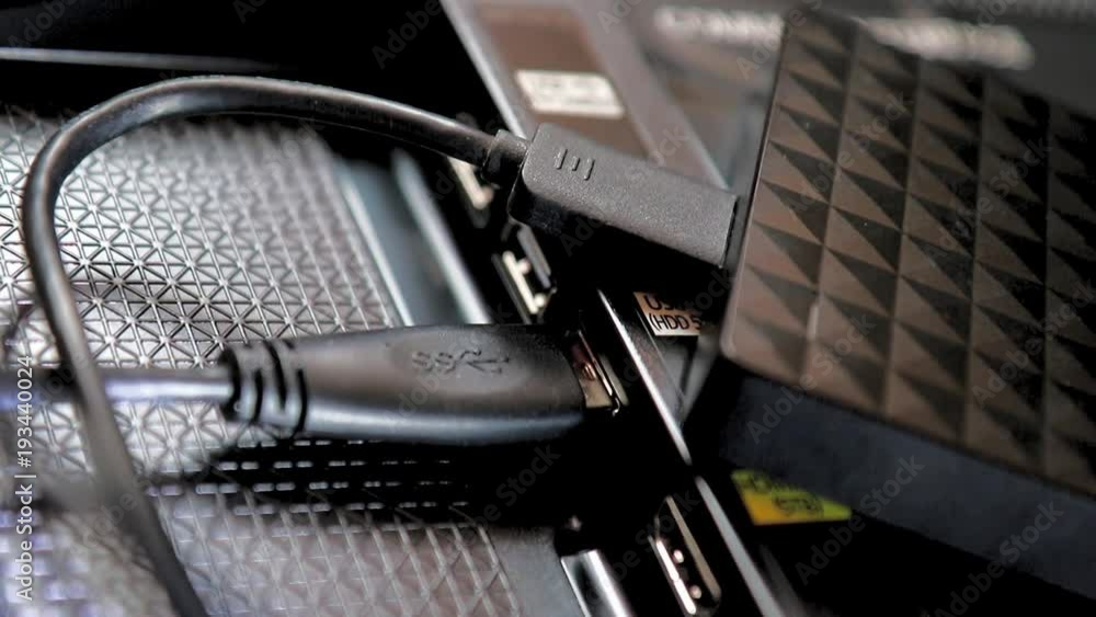 The portable drive is plugged into a slot in the back of the TV. Close-up view of copying data from the television with gradually change focusing. The portable drive is plugged into a slot in the back of the TV. Close-up view of copying data from the television with gradually change focusing.