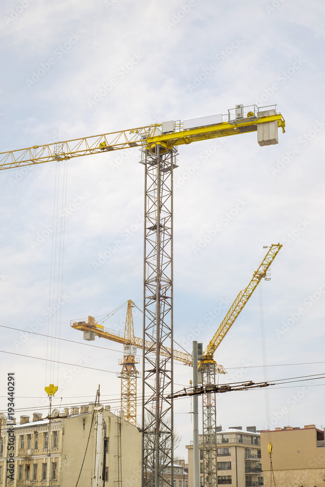 construction site, building and cranes, blue sky background