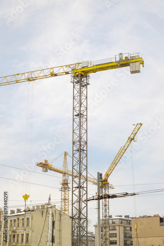 construction site, building and cranes, blue sky background