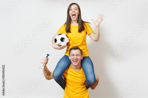 Inspired young couple, woman sit on man shoulders, fans with soccer ball pipe cheer favorite football team expressive gesticulate hands isolated on white background. Family leisure, lifestyle concept.