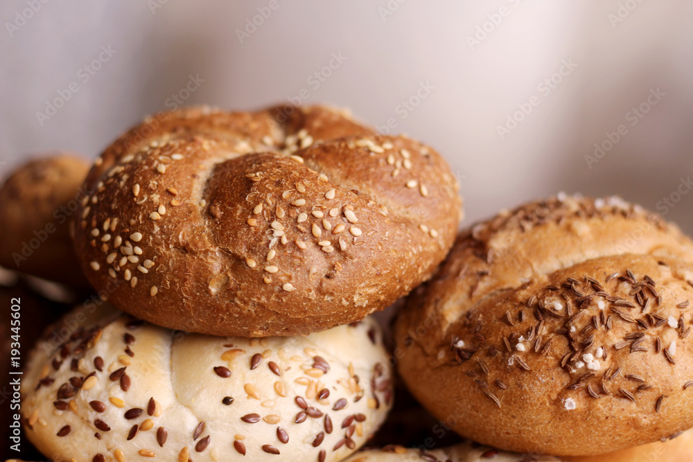 Tasty freshly baked butter kaiser roll with linseed and sunflower seeds. Top view, copy space, selective focus. Pastries on a wooden table. Blurred background. Concept of fresh pastry. Tasty freshly baked butter kaiser roll with linseed and sunflower seeds. Top view, copy space, selective focus. Pastries on a wooden table. Blurred background. Concept of fresh pastry.